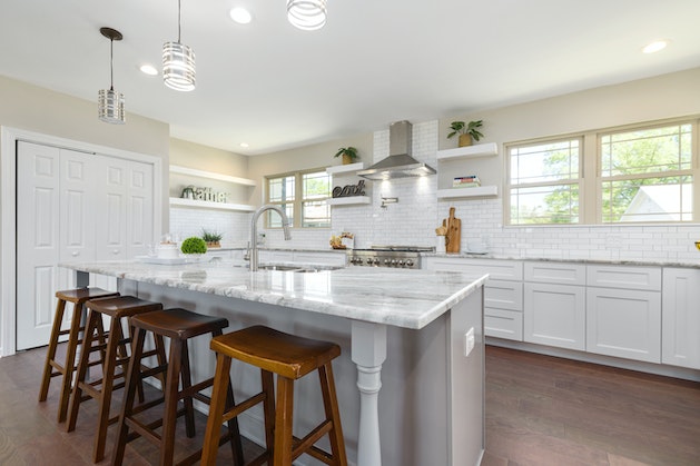 kitchen with white counters and cupboards and 4 brown stools
